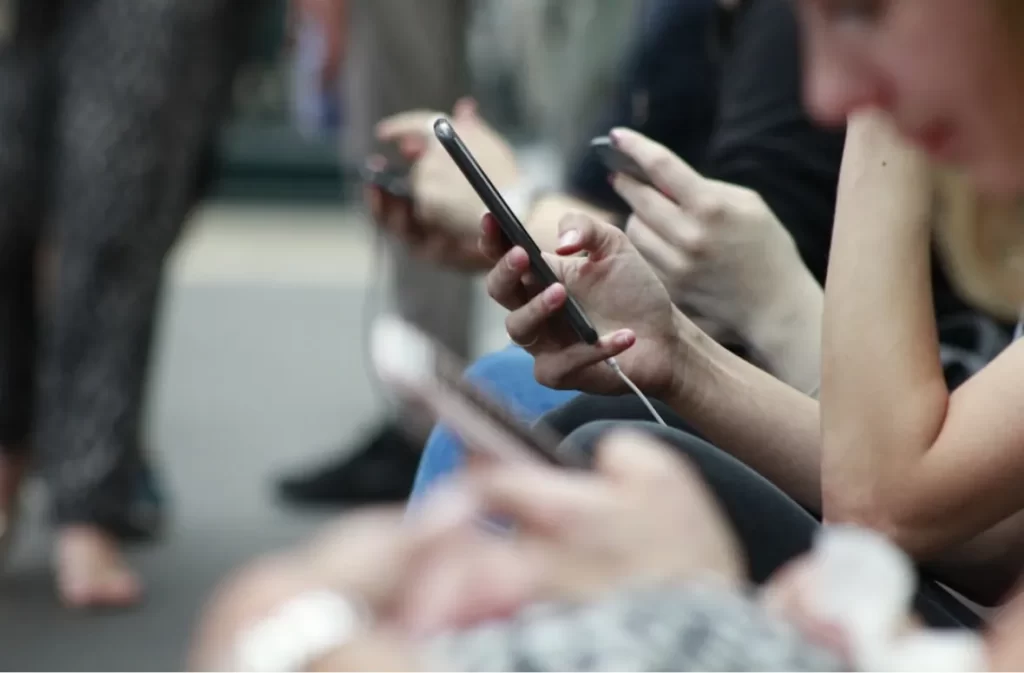 People scrolling through their phones, showcasing connectivity.